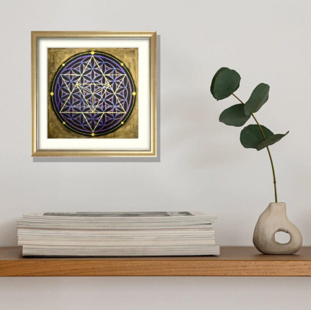 シェルフに飾られたマカバアート「宇宙」の手描き原画。シャンパンゴールド額装が雑誌と緑の花瓶に囲まれ、知性と癒しの空間を演出。波動アップと創造力を高める風水的な配置。