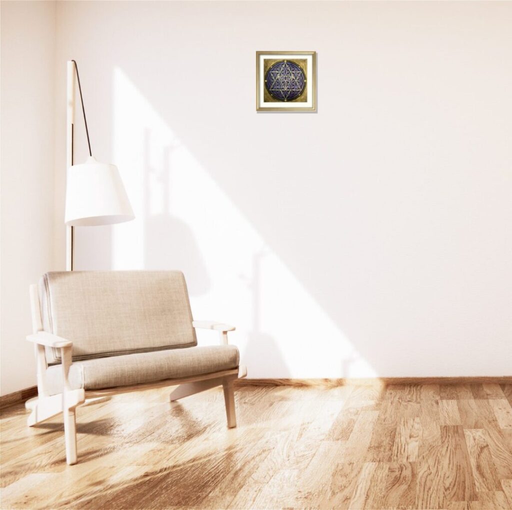 生成りのソファの背後、大きな照明の横の白い壁に飾られた神聖幾何学アート「宇宙」。シャンパンゴールド額装がリビングに高波動と安らぎをもたらす。手描き原画で空間のエネルギーを浄化。
