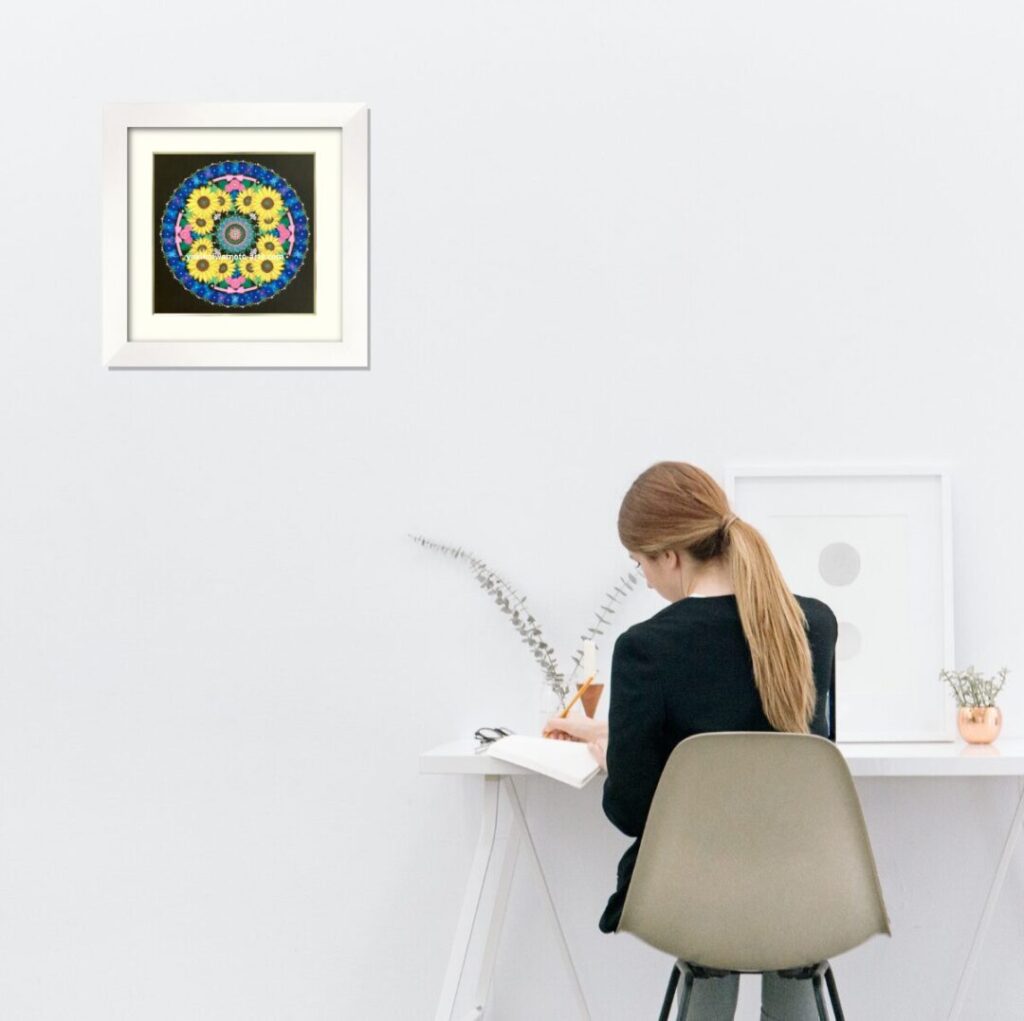 仕事運と自己肯定感を高める抽象画。白いデスクで書き物をする女性と、40cm角のひまわり曼荼羅アートが飾られたオフィス。