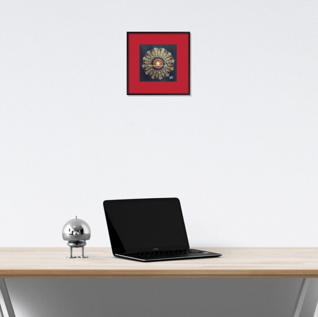 パソコンデスクの上の白い壁に映える赤い曼荼羅。クリエイティブな作業を支える視覚効果。